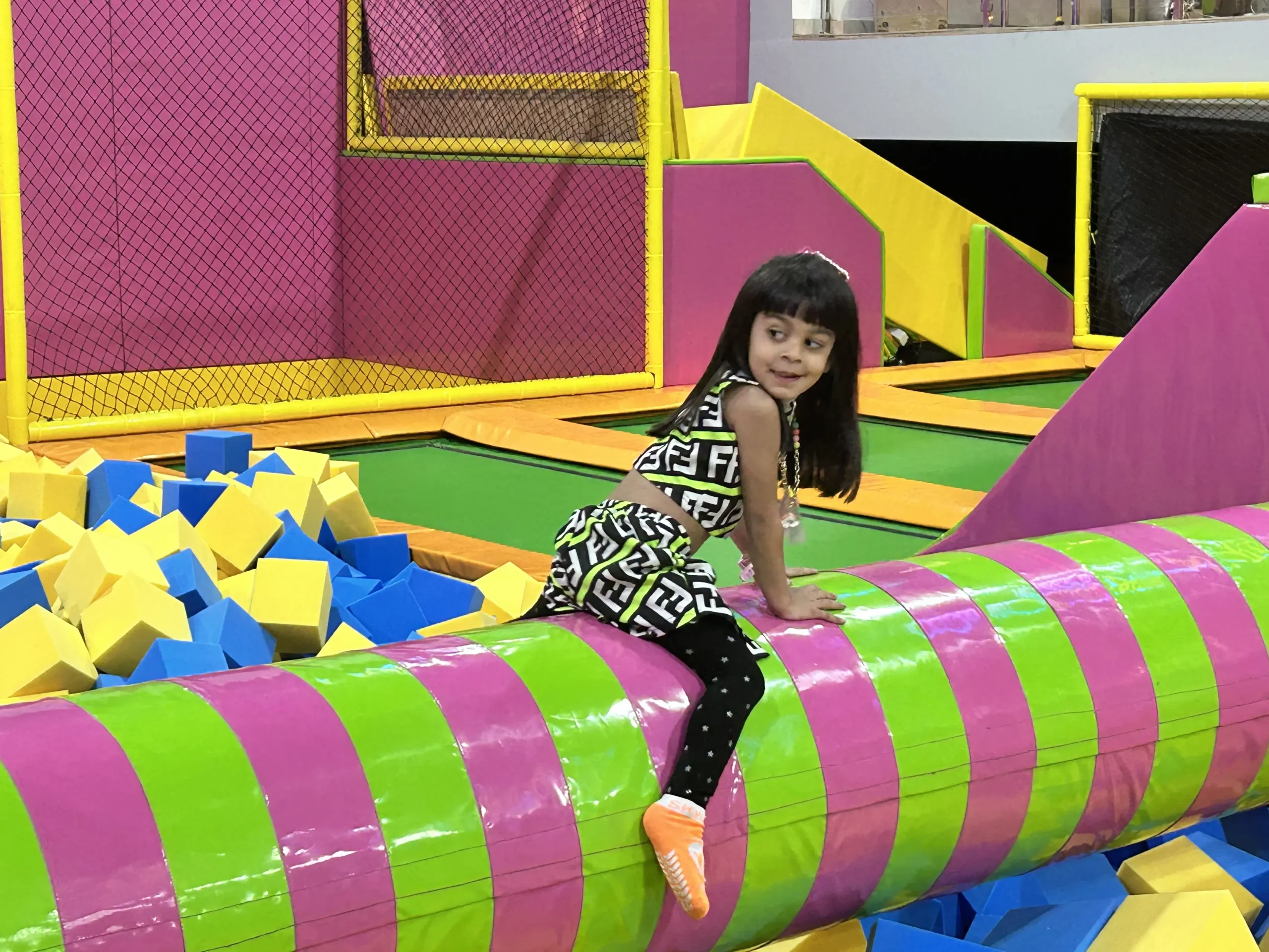 a girl sitting on foam log at skyjumper