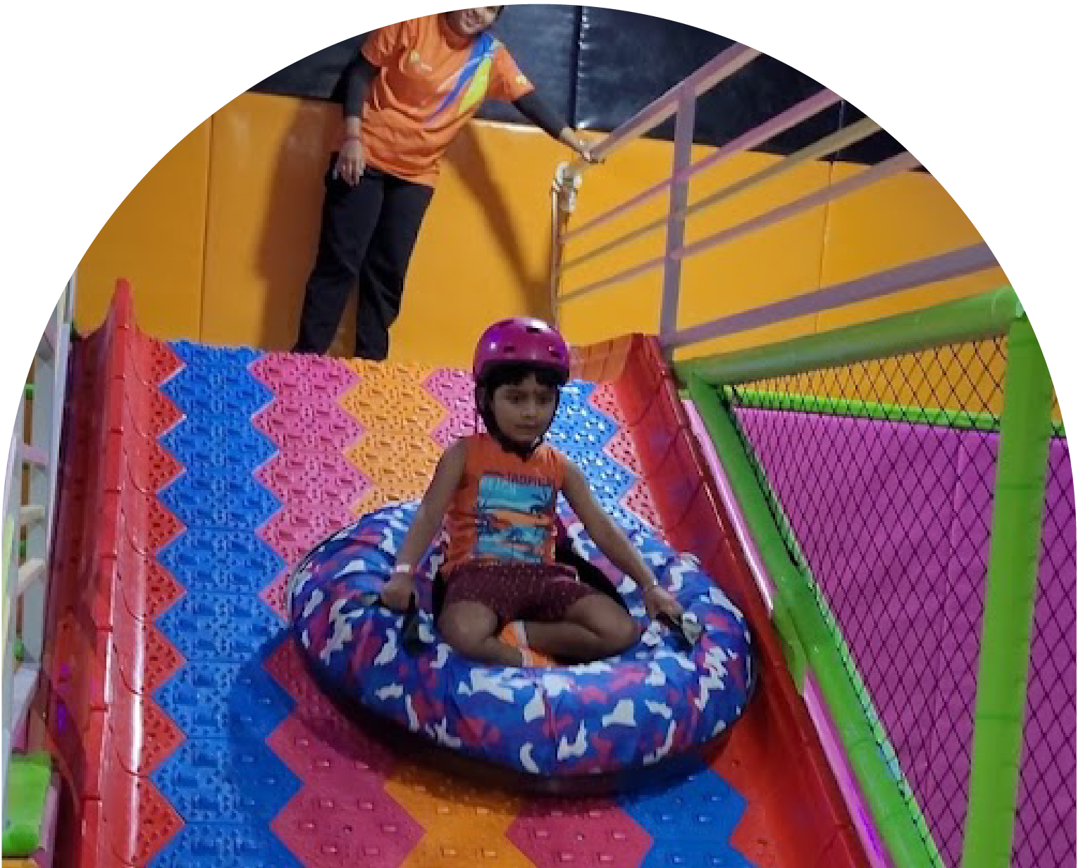 Kid sliding down in safety gear at SkyJumper